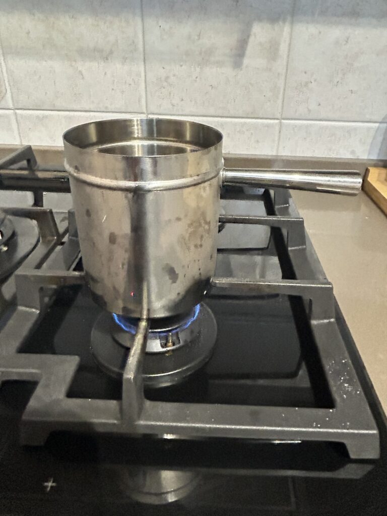 Bollitore inferiore della cuccumella sul fornello secondo il metodo off-boil.