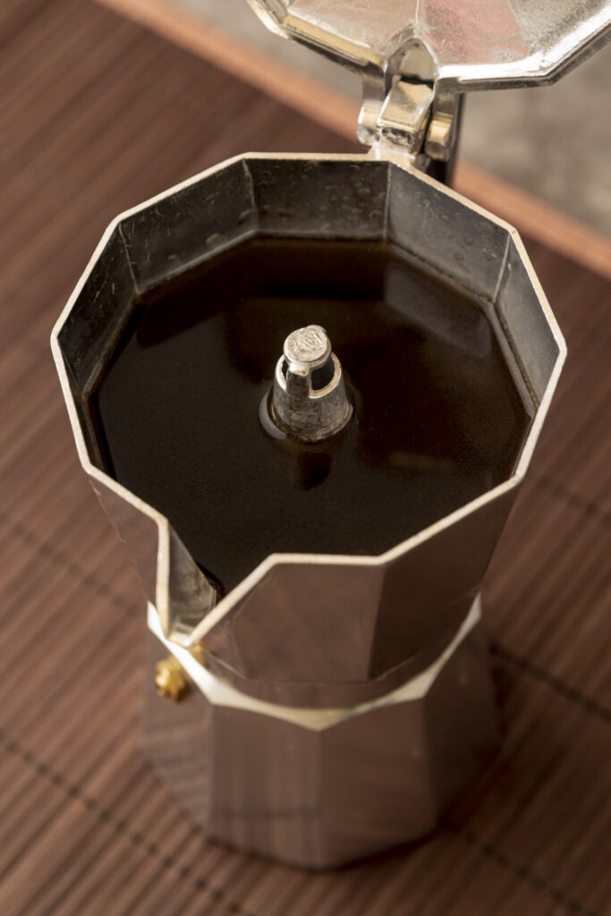 Moka appena terminata con il caffè estratto, vista dall’alto con il coperchio aperto