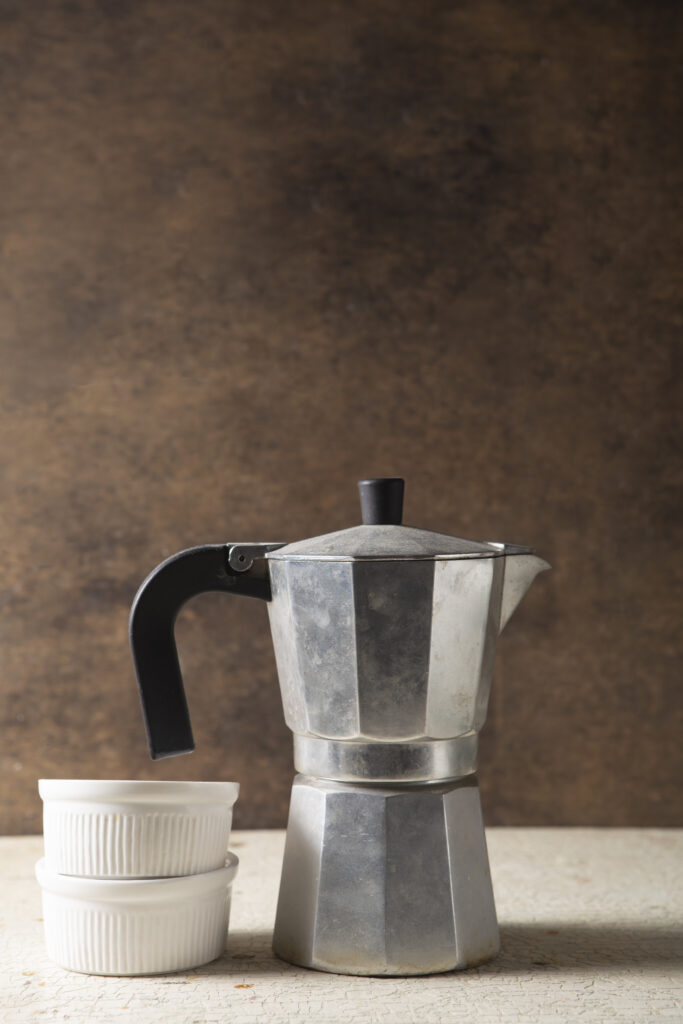 Moka vintage usata accanto a due ciotoline bianche, simbolo della sua presenza nelle case da decenni