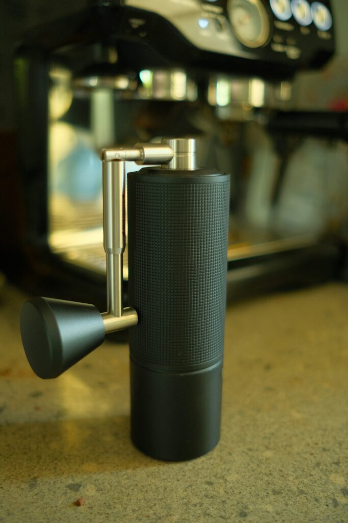 Macinacaffè manuale accanto a una macchina espresso domestica