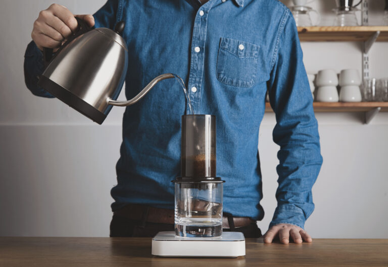 Preparazione caffè AeroPress versata acqua bollitore gooseneck su bilancia