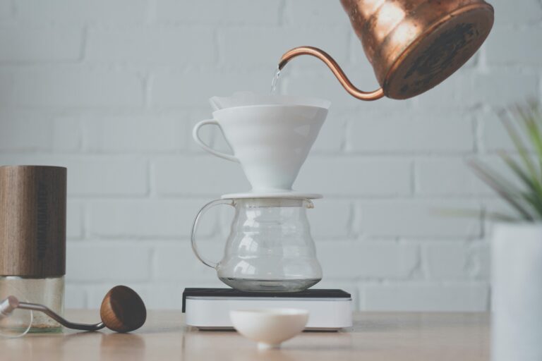 Preparazione caffè pour-over con dripper Hario V60 bianco e kettle in rame