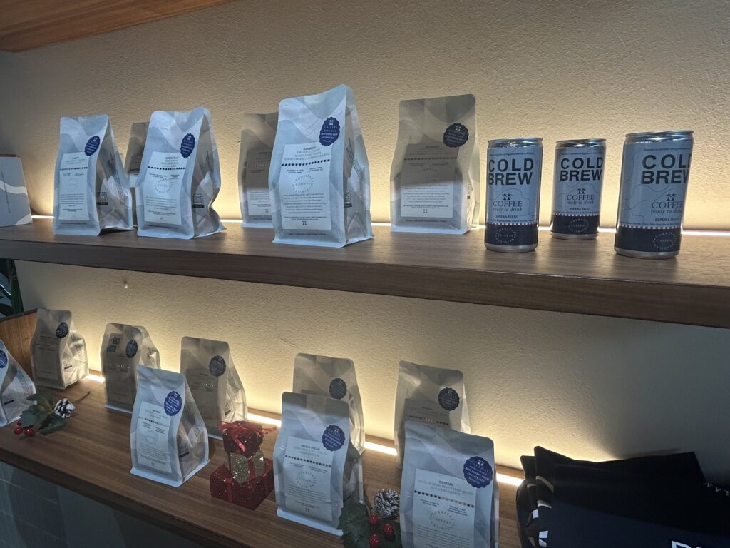 Scaffale di torrefazione con varietà di caffè specialty e cold brew artigianali